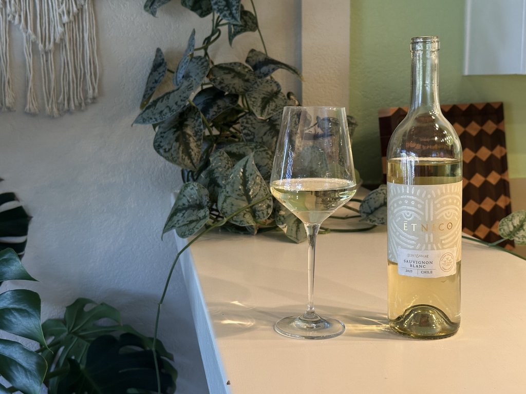 Bottle of 2025 Etnico Sauvignon Blanc next to a glass of white wine on a kitchen counter